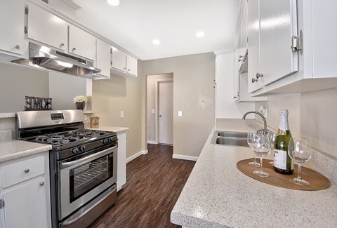 a kitchen with stainless steel appliances and a counter with a bottle of wine
